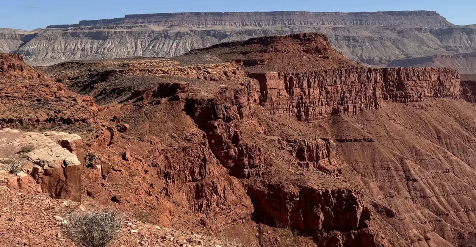 Red rock canyon cliffs and distant mesa in Southern Utah